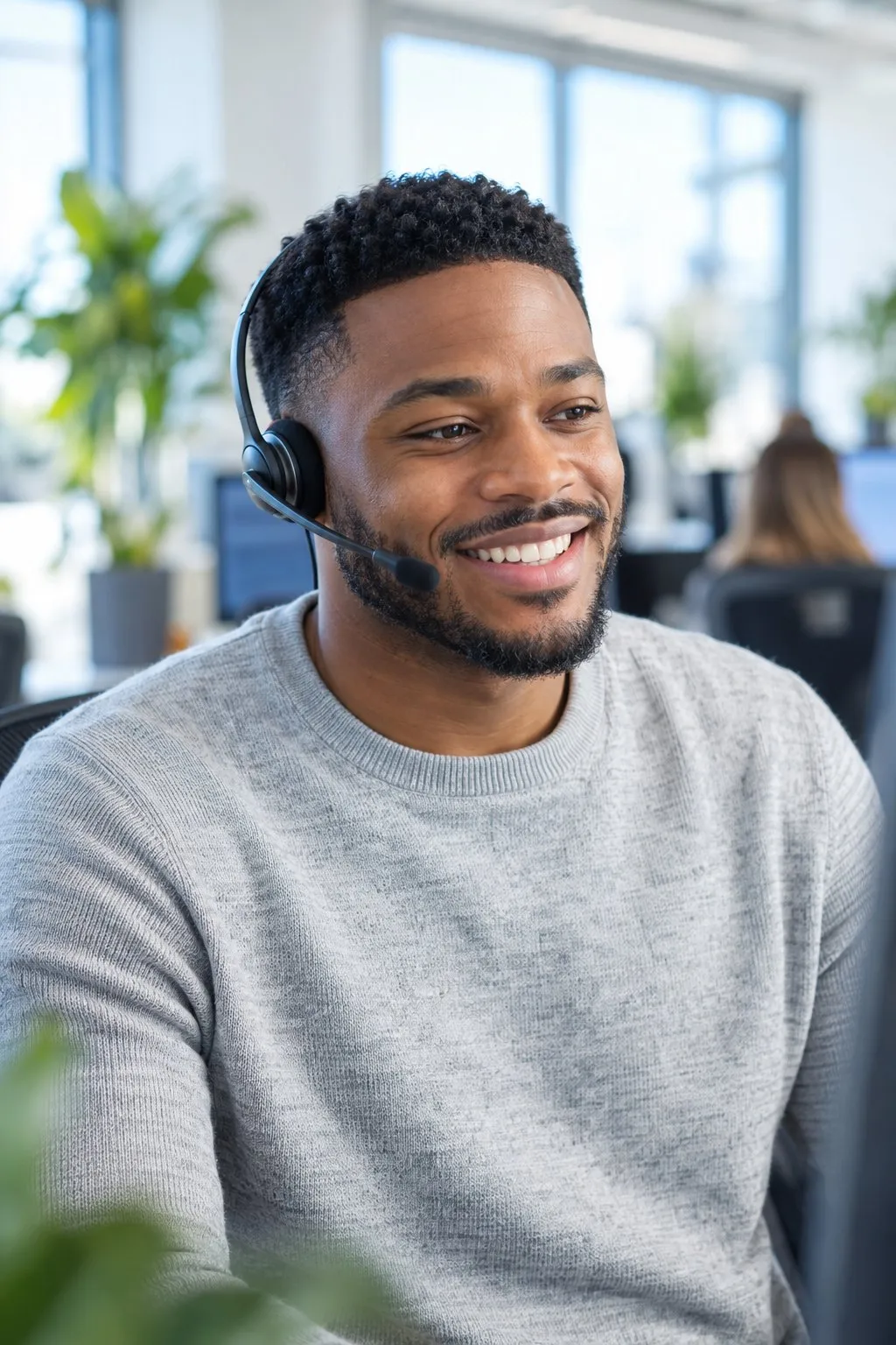A DriveHoS ELD support agent with a headset, smiling on a call
